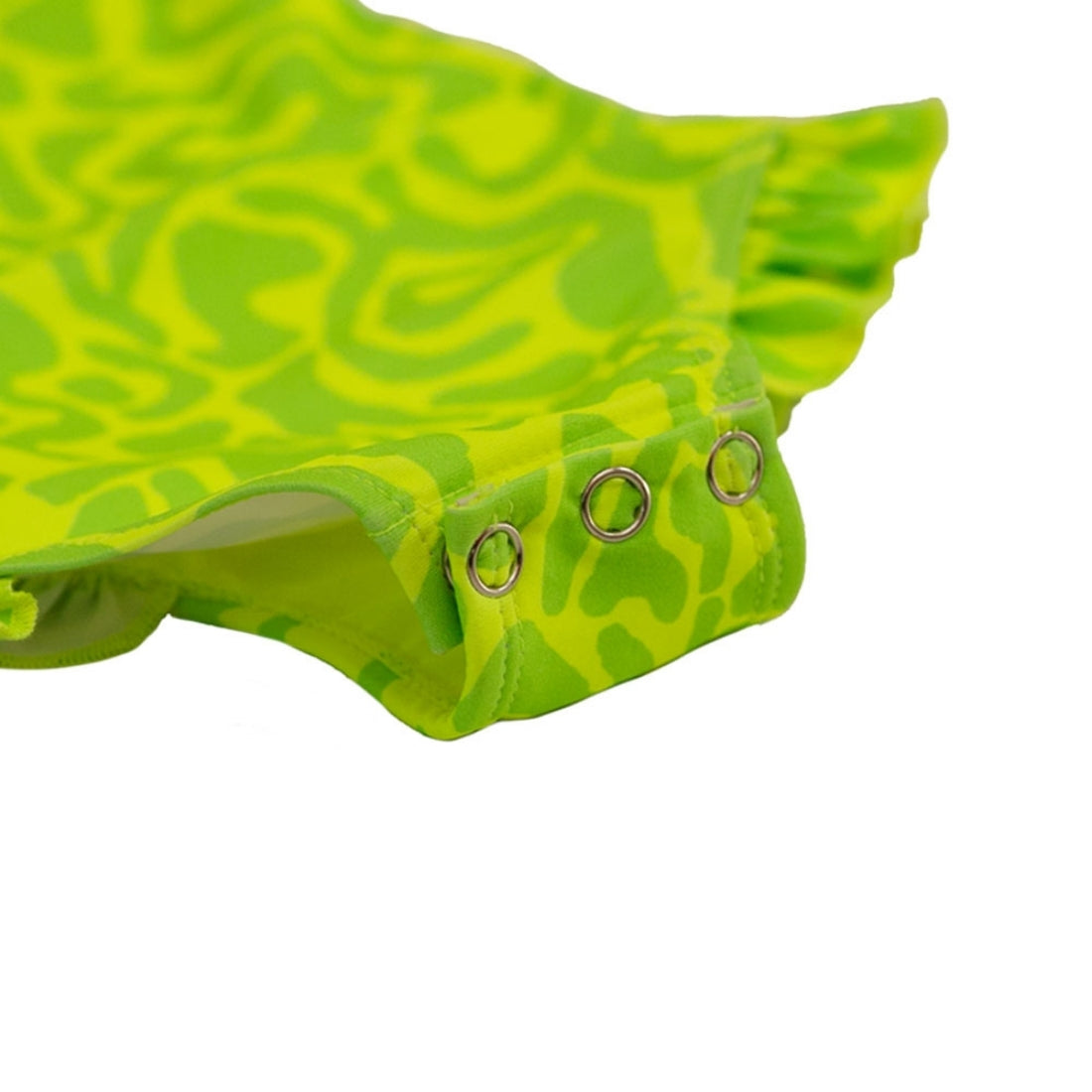 Close-up of a Vizzies Swim girls one-piece frill swimsuit in bright lime light pattern, showing the crotch snaps and ruffle details. 