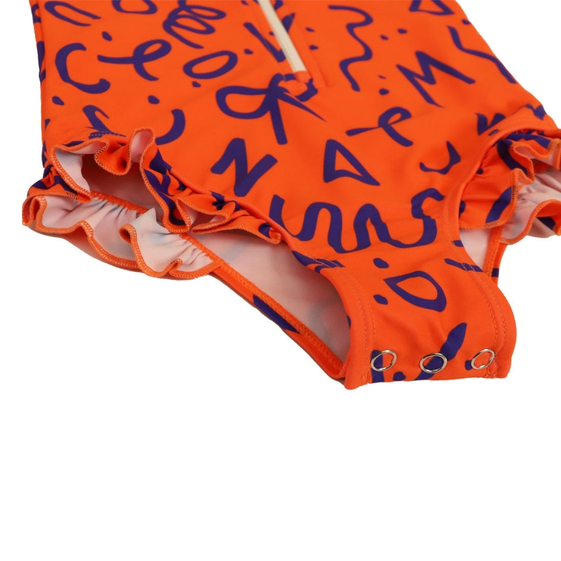 Close-up of a Vizzies Swim girls one-piece frill swimsuit in bright squiggle pop pattern, showing the crotch snaps and ruffle details. 