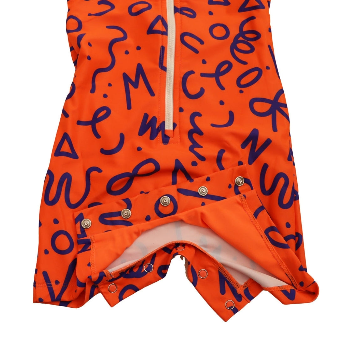 Bright squiggle pop print long-sleeve baby swimsuit from Vizzies Swim with a zipper front and crotch snaps, laid flat on a white background.