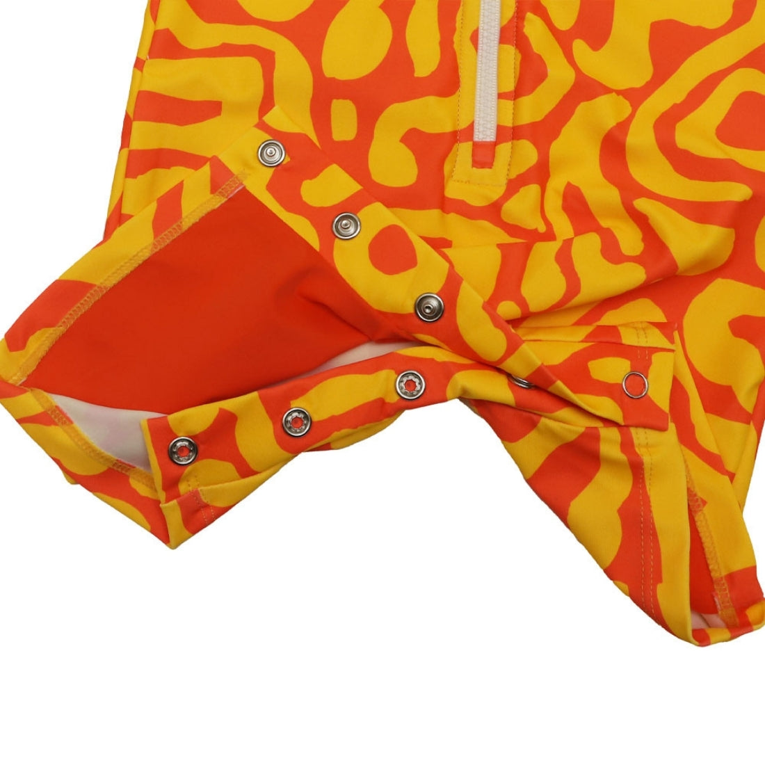 Bright sunburst print long-sleeve baby swimsuit from Vizzies Swim with a zipper front and crotch snaps, laid flat on a white background.