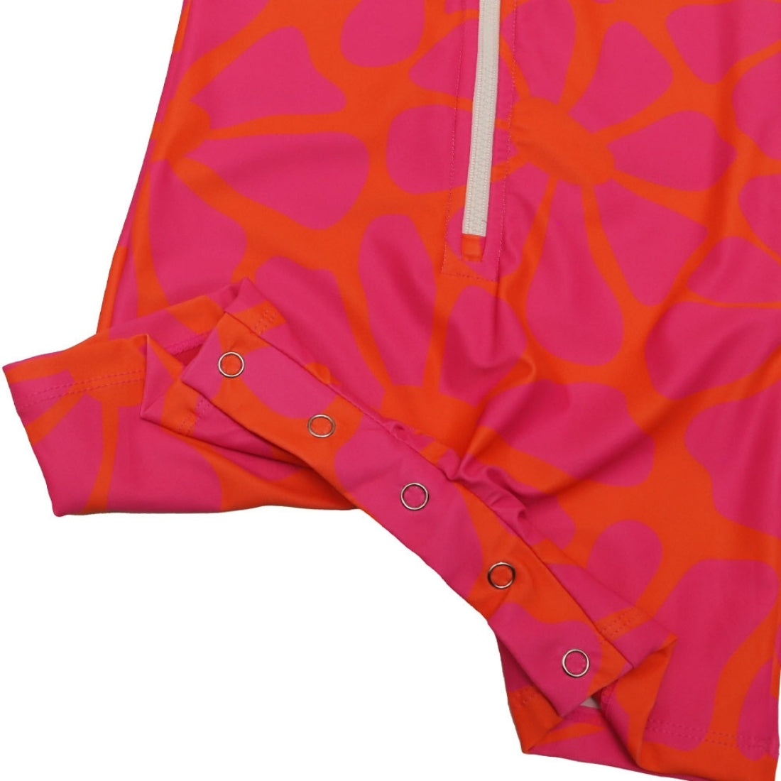 Bright tangy blossom print long-sleeve baby swimsuit from Vizzies Swim with a zipper front and crotch snaps, laid flat on a white background.
