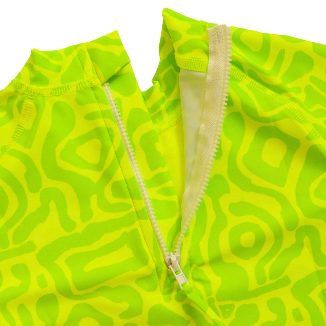 Close-up of a bright lime light print kids swim rashie with a white zipper running vertically down the centre.