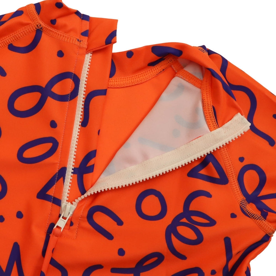 Close-up of a bright squiggle pop print kids swim rashie with a white zipper running vertically down the centre.